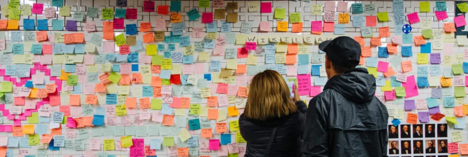 People look at post-it notes covering a wall as part of the art piece 'Subway Therapy' at the Union Square subway station in Manhattan, New York, on Nov. 13